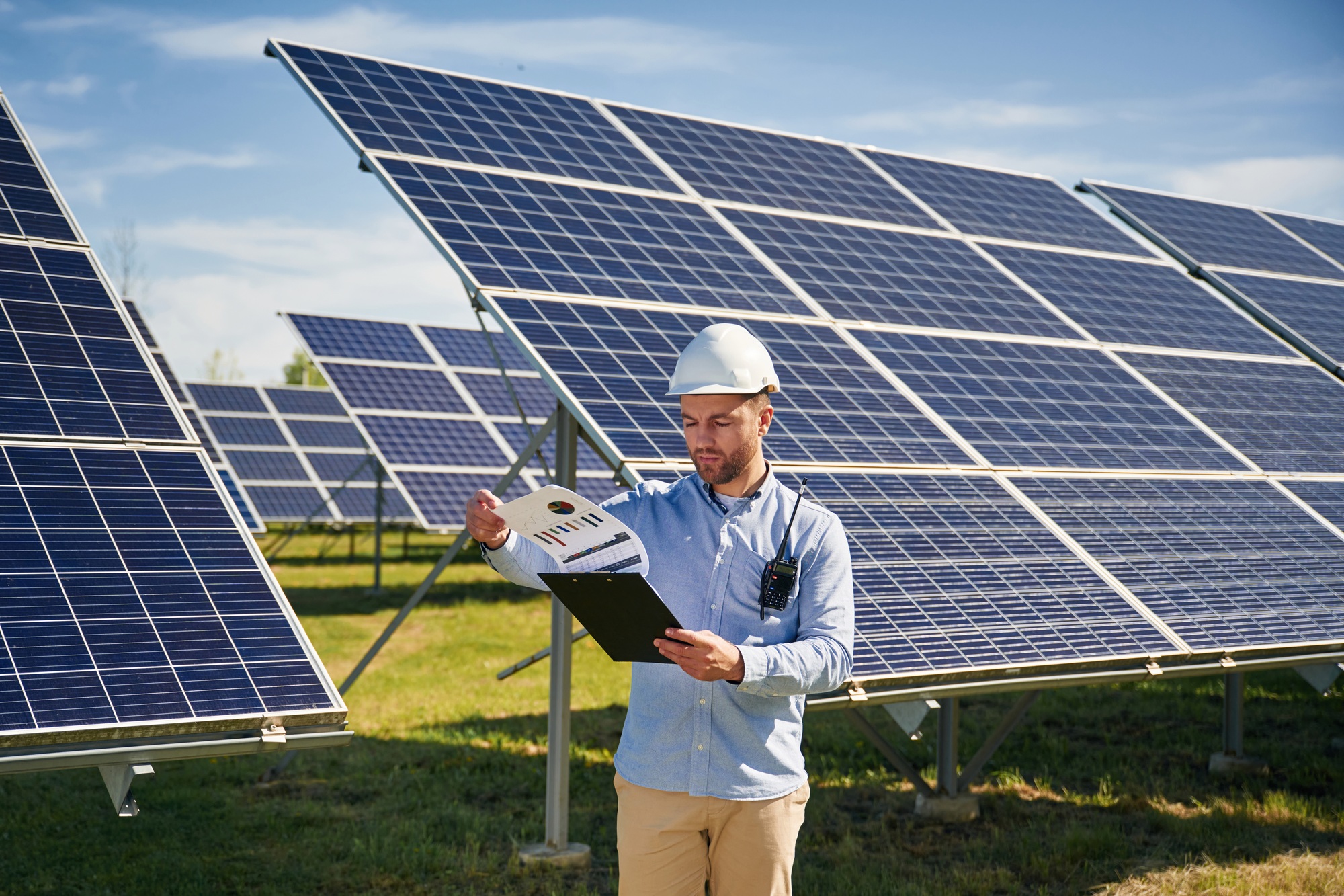 Sunny daytime. Engineer with photovoltaic solar panels outdoors